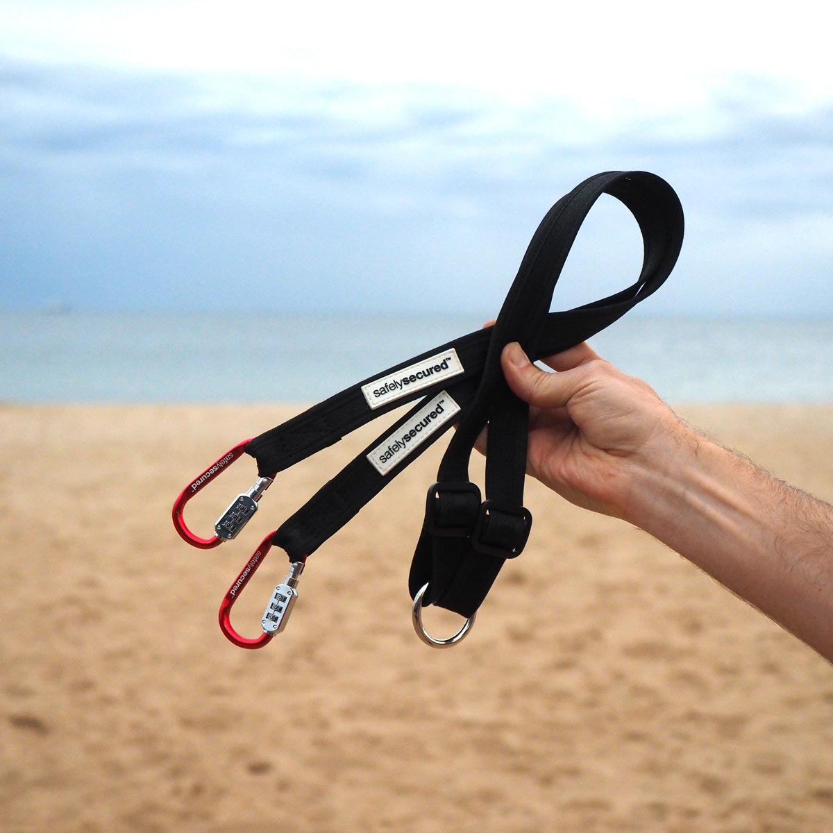 PIcture of mans hand holding the lead splitter with a beac in the background